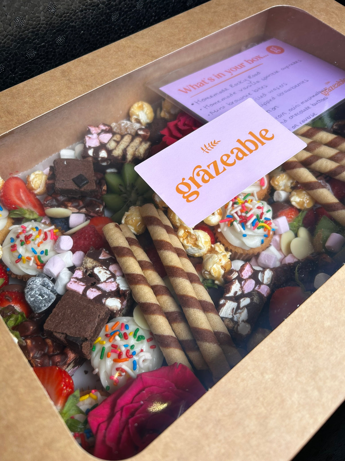 Assorted small treats in a box with a 'grazeable' card.