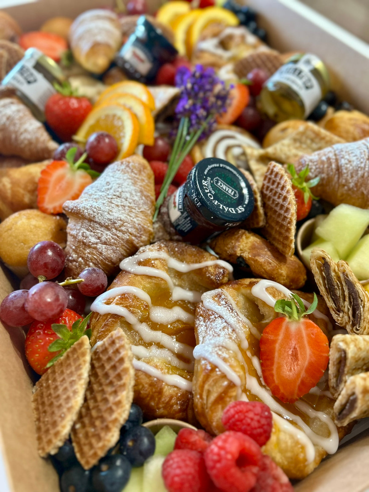 Assorted pastries, fruits, and jams on a platter