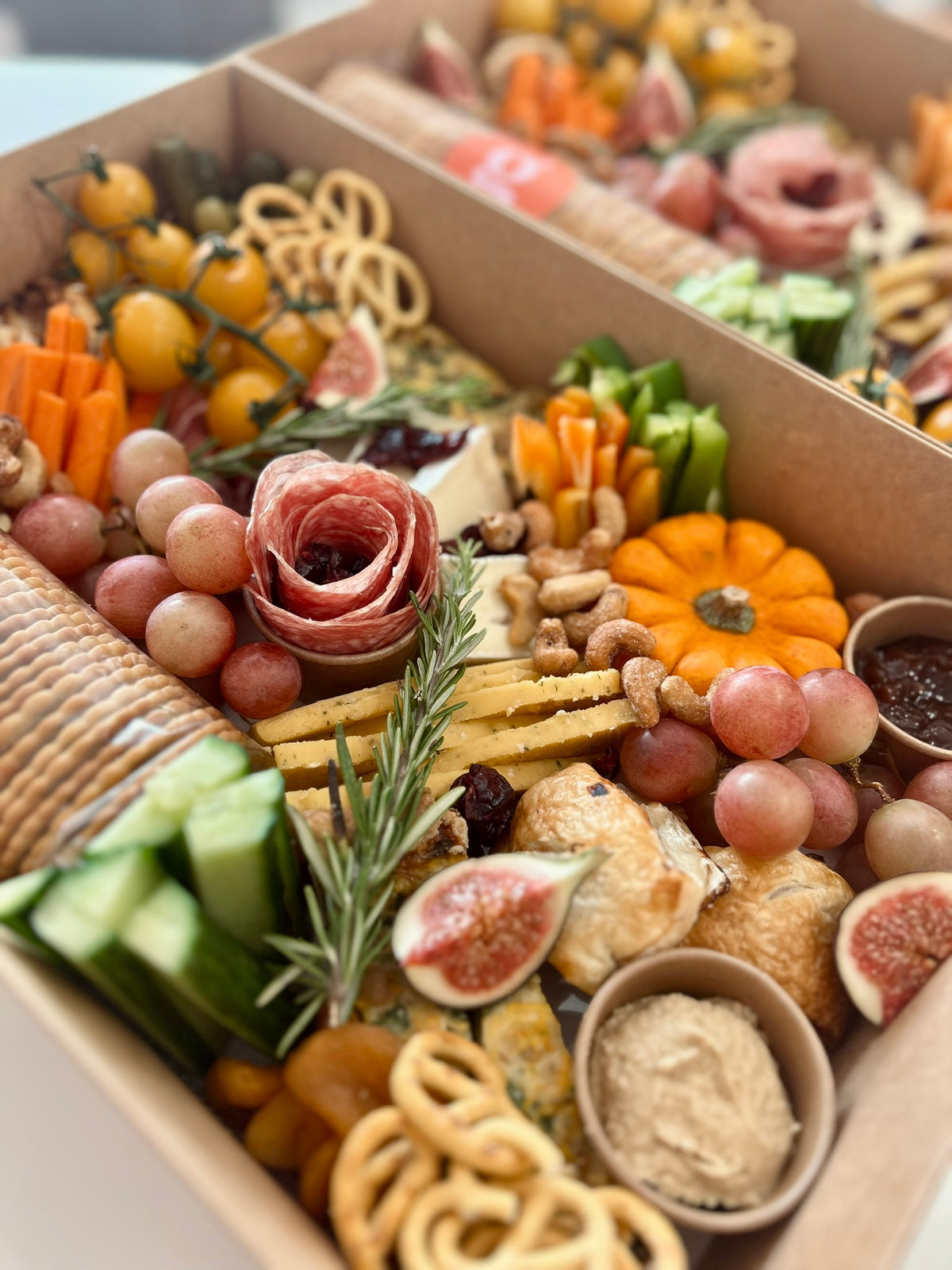 savoury food items with fruits, meats, cheese, crackers in a box