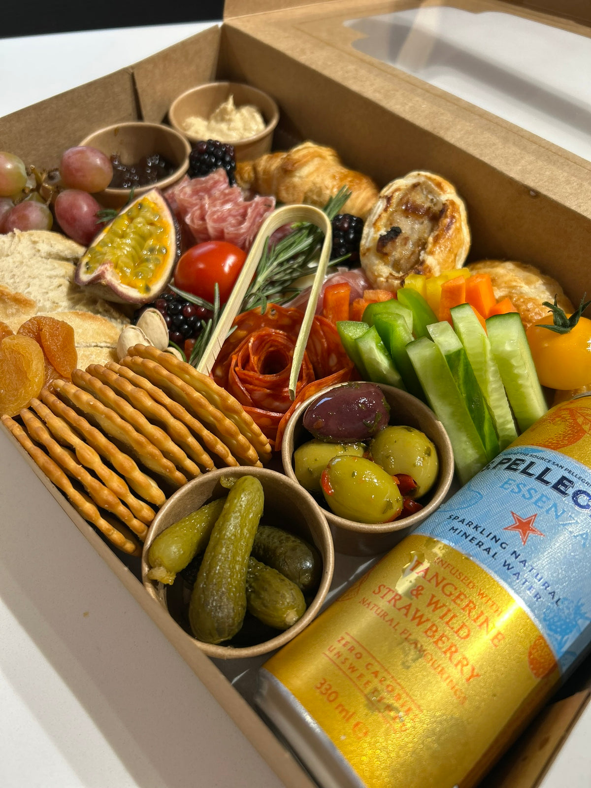 Assorted savoury snacks and a can of fizzy water in a box
