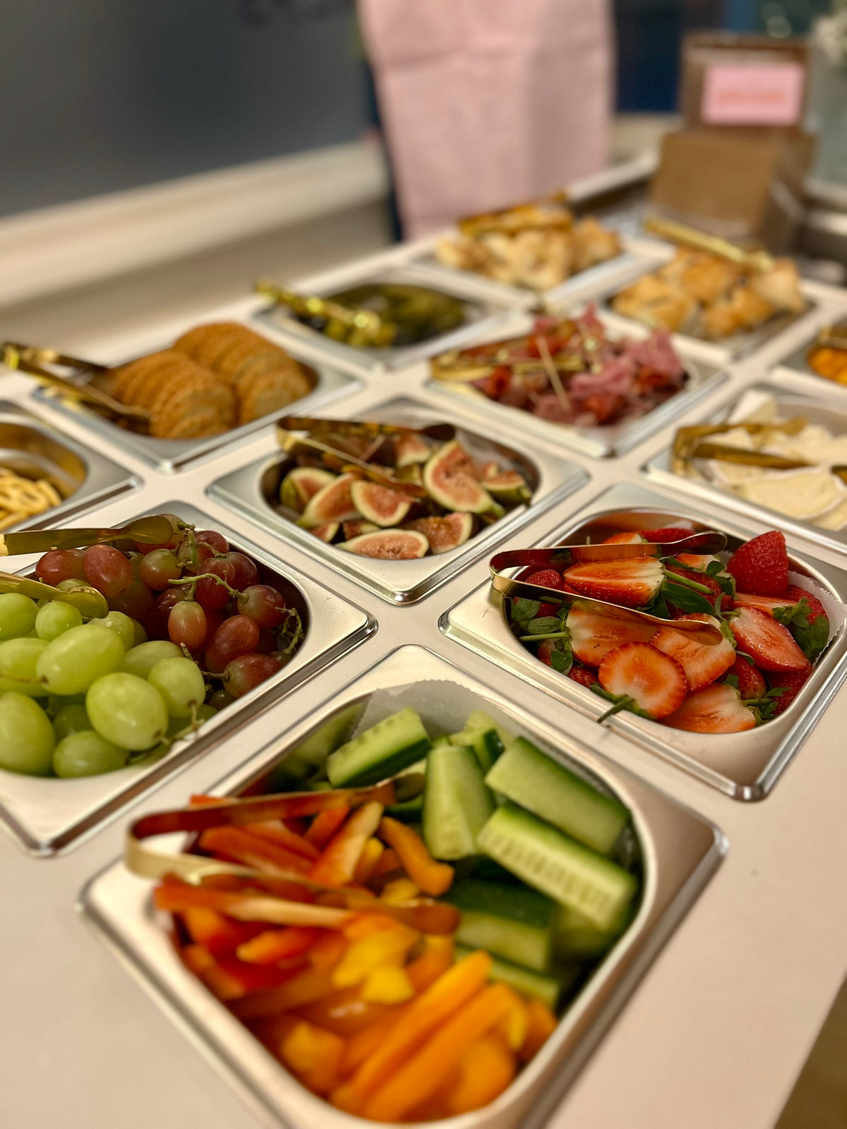 Assorted fruits, vegetables, and pastries in small containers in the charcuterie bar
