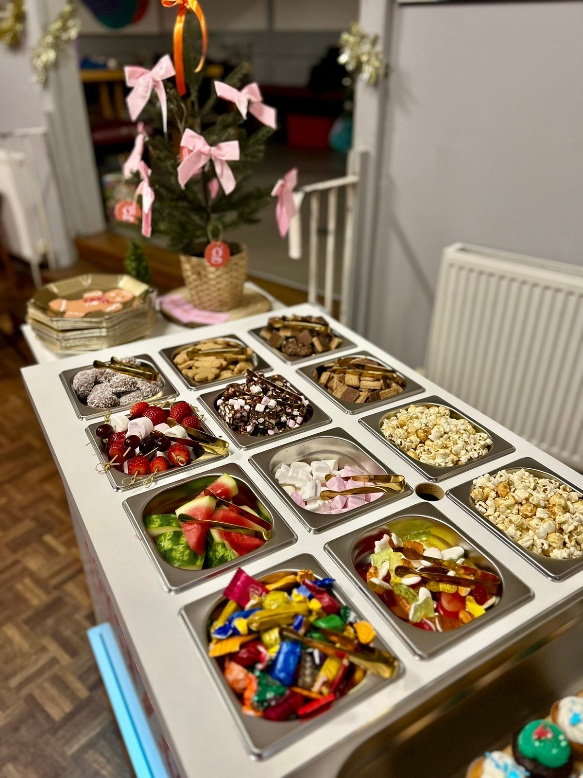 Dessert bar with sweet food items with a small Christmas tree for decoration 